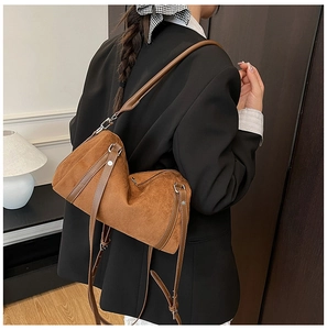 Brown frosted suede Boston bag with leather strap and silver buckles shown on a model