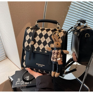 Detailed view of checkered crossbody bag with mirror reflection and cute rabbit charm