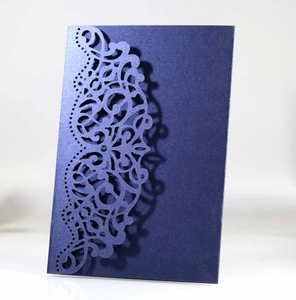 Detail of navy blue pearl paper laser cut lace invitation with elegant metallic texture