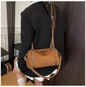 Brown suede cylindrical Boston bag with leather trim shown on a model for daily use