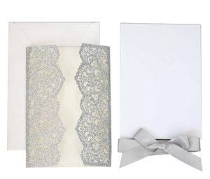 Elegant laser-cut silver glitter wedding invitation set with white ribbon and envelope