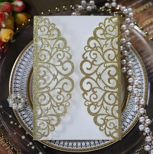 Detail of laser cut gold glitter wedding invitation with heart and vine patterns