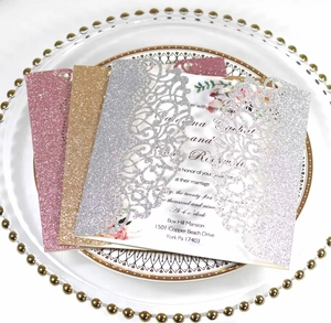 Invitations de mariage à paillettes découpées au laser en rose or et argent sur plateau
