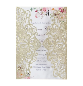 Detail of laser-cut gold glitter wedding invitation with elegant pink floral inner card