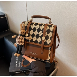 Detail of retro tweed check backpack with leather trim and cute rabbit pendant
