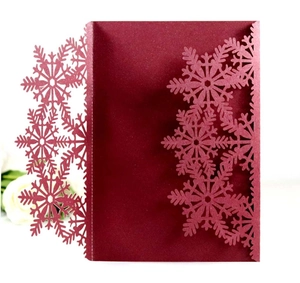 Détails macro de motifs de flocons découpés au laser sur papier spécial bordeaux foncé