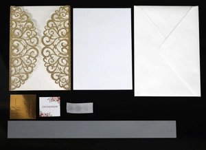 Macro detail of laser-cut gold glitter wedding invitation set with floral patterns