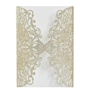 Close-up of laser-cut hollow floral pattern on champagne gold glitter wedding invitation