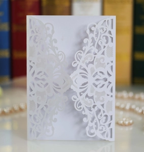 Detailed laser-cut white wedding invitation with intricate European floral pattern