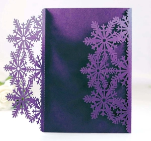 Détails de flocons de neige découpés au laser sur une carte d'invitation violet foncé