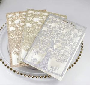 Detailed laser-cut glitter invitations featuring intricate tree and butterfly patterns