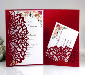 Macro shot of laser-cut burgundy wedding invitation set with floral inner card detail
