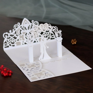 Detailed laser-cut 3D wedding invitation showing couple under a floral archway
