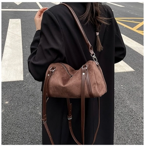Detail of vintage brown suede shoulder bag with leather strap and silver buckle