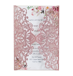 Close-up of laser-cut rose gold glitter wedding invitation with intricate floral hollow design