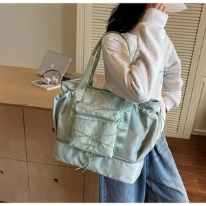 Detail view of large mint green travel tote showing bottom wet-dry separation compartment
