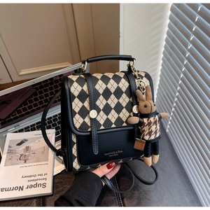 Detail of vintage quilted backpack with leather trim and decorative bunny pendant