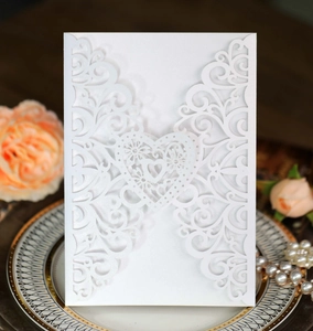 Detail of laser-cut heart invitation cover in pearl white with intricate hollow pattern