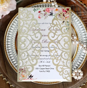 Detail view of laser-cut wedding invitation with gold glitter texture and floral card