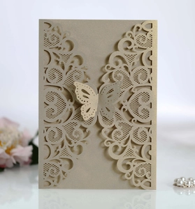 Detail of laser-cut butterfly wedding invitation with shimmering gold lace patterns