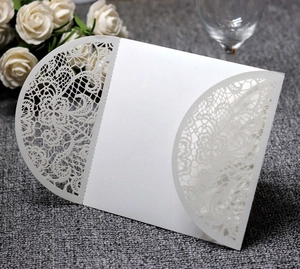 Detailed laser-cut white lace wedding invitation cover with elegant pearl paper texture