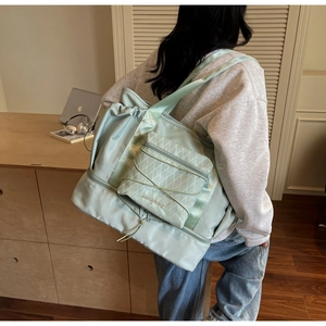 Close-up of mint green travel bag with diamond quilt pattern and elastic cord detail