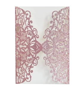 Detail of pink glitter laser cut invitation cover with elegant hollow floral pattern