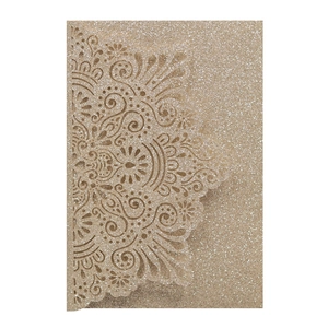 Dettaglio macro del cartoncino glitterato oro con intricati motivi floreali laserati