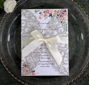 Silver glitter laser cut wedding invitation with rose floral card and cream satin bow