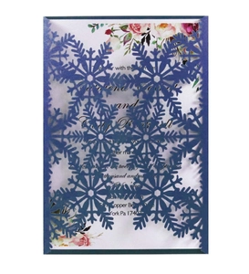 Détail de flocon de neige découpé au laser sur enveloppe bleue et carte florale