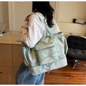 Detail of light green waterproof travel bag showing front pocket and durable nylon texture