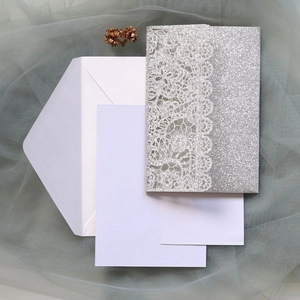 Detailed set of silver glitter laser-cut wedding invitations with envelopes and blank inserts