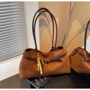 Detail of vintage brown suede tote bag with wooden beads and decorative metal buckle