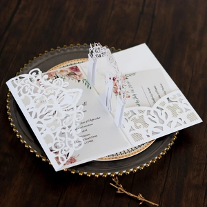Detailed laser-cut 3D wedding invitation with elegant lace pattern and floral interior