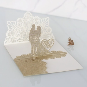 Dettaglio dell'invito di nozze 3D con glitter dorati e intaglio laser cuore Mr & Mrs