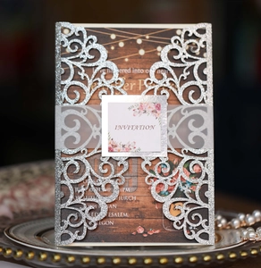 Detail view of silver glitter laser-cut wedding invitation with elegant floral card