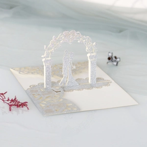 Détail d'une carte de mariage 3D avec un couple pailleté sous une arche en cœur