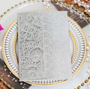 Detail of silver glitter laser cut wedding invitation with elegant lace floral patterns