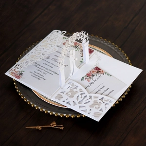 Detail of laser-cut 3D pop-up wedding invitation with intricate floral hollow design