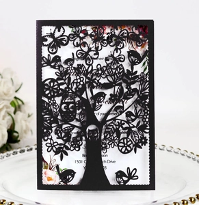 Detail of laser-cut black card featuring intricate tree, owl and butterfly patterns
