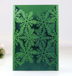 Détail d'une enveloppe d'invitation vert foncé avec motif flocon de neige découpé au laser