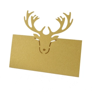 Macro detail of laser-cut reindeer pattern on golden pearlescent paper table card