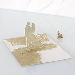 Dettaglio di pizzo tagliato al laser su invito di nozze glitterato con motivo Mr & Mrs