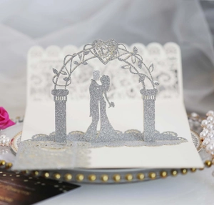 Detail of laser-cut 3D wedding invitation with silver glitter heart arch and couple