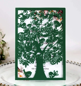 Laser cut dark green greeting card with intricate tree and bird patterns for invitations