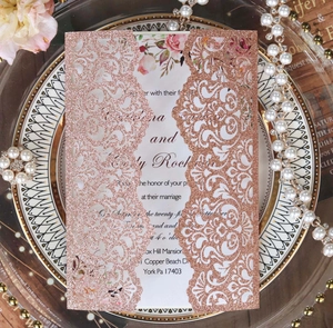 Close-up of laser cut rose gold glitter wedding invitation with elegant floral insert