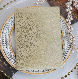 Dettaglio dell'invito di nozze glitter oro tagliato al laser con motivi mandala complessi