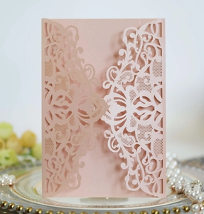 Detailed laser-cut hollow floral pattern on light pink pearlescent invitation card