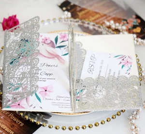 Detailed laser-cut silver glitter wedding invitation with floral insert and RSVP card