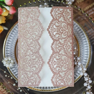 Detail of rose gold glitter laser-cut floral wedding invitation with intricate patterns